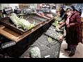 متسوقون يرتدون أقنعة واقية أصناء شراء الخضروات في متجر بووهان