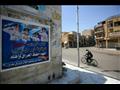 عراقي يقود دراجته قرب ملصق يحض الناس على اتخاذ الا