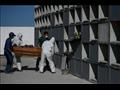 عمال بصدد وضع نعش في صندوق دفن في مقبرة بريو دي جي