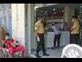 حراس يضعون الكمامات يقفون أمام مستشفى الكوبي في عد