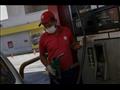 عامل في محطة وقود يضع قناعا وقفازات في كراكاس