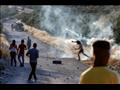 متظاهر فلسطيني يعيد رمي عبوة غاز مسيل للدموع خلال 