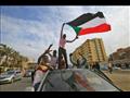 متظاهرون يرفعون العلم السوداني خلال احتجاجات على م