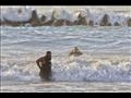 رجال الإنقاذ يصارعون الأمواج في شاطئ النخيل