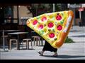 امرأة تحمل عوامة على شكل شريحة بيتزا في برشلونة