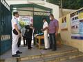 امين شرطة يقوم بتوزيع الكمامات مجانا على الناخبين