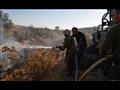 جنود إسرائيليون يخمدون حريقاً قرب كيبوتز كيسوفيم ا