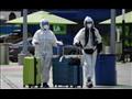 مسافران يرتديان ملابس واقية في مطار لوس أنجليس