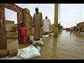 سودانيون يمشون على أكياس من الرمل للوصول إلى منازل