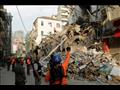 عمال إنقاذ يحفرون بين كومة من الركام في مبنى في شا