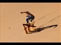 سائح يمارس رياضة التزلج على الرمال في دبي