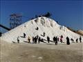 مواطنون يستمتعون بالشمس المشرقة على جبال الملح في بورسعيد