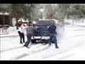 سكان يساعدون سائقا علقت سايرته في الثلج في تكساس