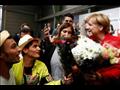 لاجئون سوريون يقدمون الأزهار للمستشارة الألمانية أ