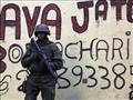 جندي برازيلي أمام رسم غرافيتي يروّج لقضية لافا جات