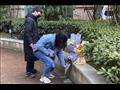 صينية تضع باقة من الزهور خلف مستشفى ووهان المركز في ذكرى وفاة أول طبيب صيني أبلغ عن كورونا
