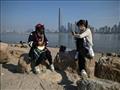 شابتين تستخدمان هاتفهما على إحدى ضفاف نهر يانغتسي 