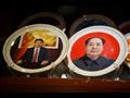 تذكارات عليها صور الرئيس الصيني شي جينبينغ (يسار) 