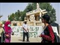 مواطنين يمرون اما تمثال لعربة محمد بوعزيزي
