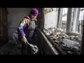 امرأة تنظف منزلها المتضرر بعد قصف مدفعي من منطقة في دونيتسك تحت سيطرة الانفصاليين المدعومين من روسيا