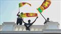 متظاهرون سريلانكيون يحملون أعلام بلدهم على مبنى رئ