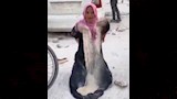 سيدة فلسطينية تجمع الدقيق من الأرض
