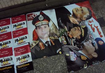 ''الدستور الجديد وعليه قانون التظاهر هدية''.. بضاعة ''حسن'' أمام ''المترو''