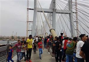 صور| مواطنون يحتفلون بأول أيام العيد على الممشى الزجاجي بمحور روض الفرج