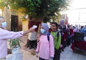 كمامة وفحص للطلاب في أول أيام العام الدراسي الجديد بأسيوط- صور