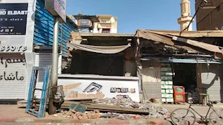 بالصور- مواطن يقتحم 3 محال تجارية في قنا بـ "لودر" ويدمرها 