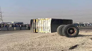 بالصور- توقف الحركة بطريق السويس بعد انقلاب تريلا محمّلة بالسن