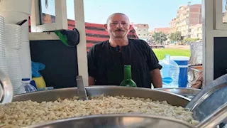 "اللي يكسب قلوب الناس يرزق".. حكاية بائع كشري يجر عربة خشبية في قرى منيا القمح