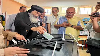 بعلم مصر.. مطران بورسعيد يدلي بصوته في انتخابات مجلس الشيوخ - صور 