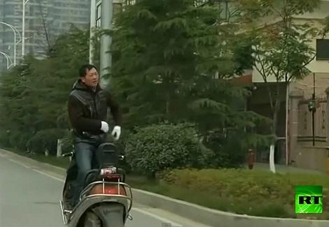 صيني يقود دراجته النارية بطريقة خاصة