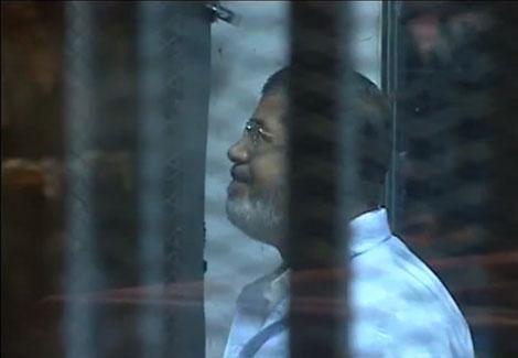 مرسي لأول مرة "مبتسماً" من داخل القفص إثر تنحي هيئة الدفاع