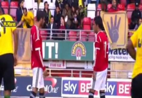 ''شعار رابعة'' يظهر في مباراة مصر وجامايكا والأمن ينزع اللافتات