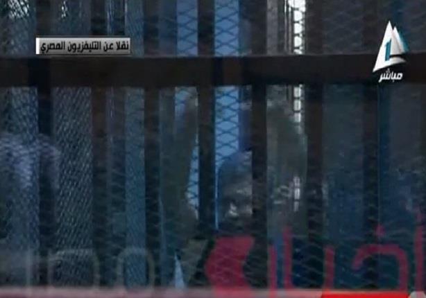 مرسي يلوح بيده قبل النطق بالحكم في قضيتي التخابر واقتحام السجون