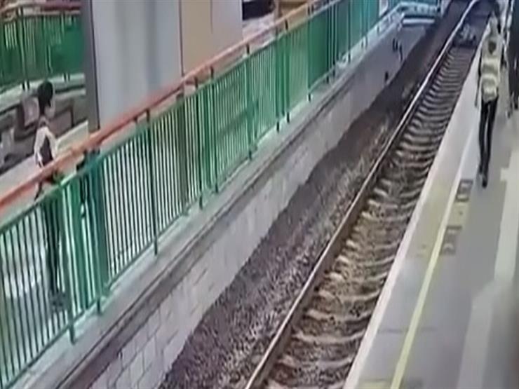 رجل يلقي امرأة على قضبان السكة الحديد بالصين -فيديو