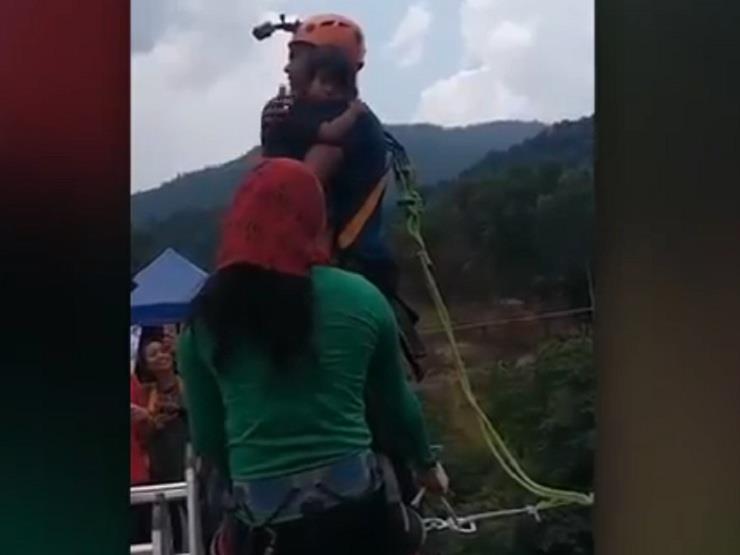 شاهد.. رجل يقفز بابنته الرضيعة من جسر ارتفاعه 200 قدم (فيديو)