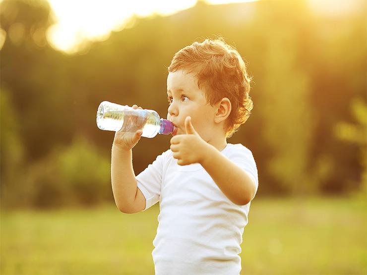 صورة طفل يشرب ماء جالس