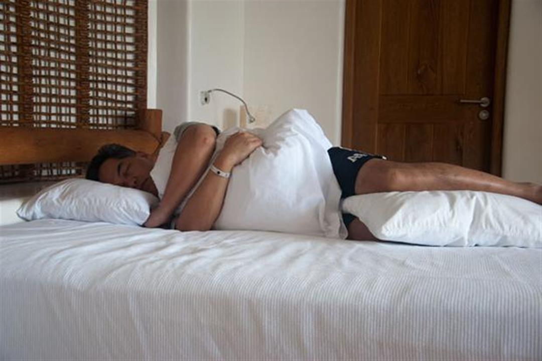 لمحبي النوم بهذه الطريقة.. وضع الوسادة بين الساقين يحمي العضلات من التقلص