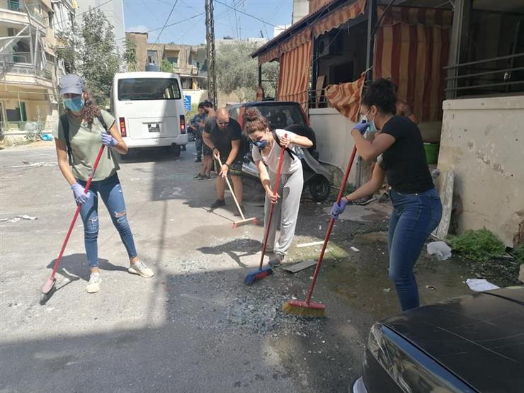 لبنانيون ينظفون الشوارع من آثار انفجار بيروت