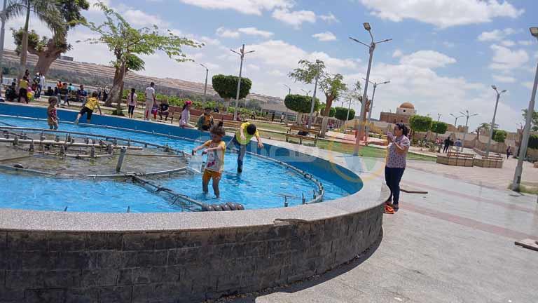 بالصور- أطفال في المنيا يحولون النافورات العامة إلى حمامات سباحة في شم النسيم