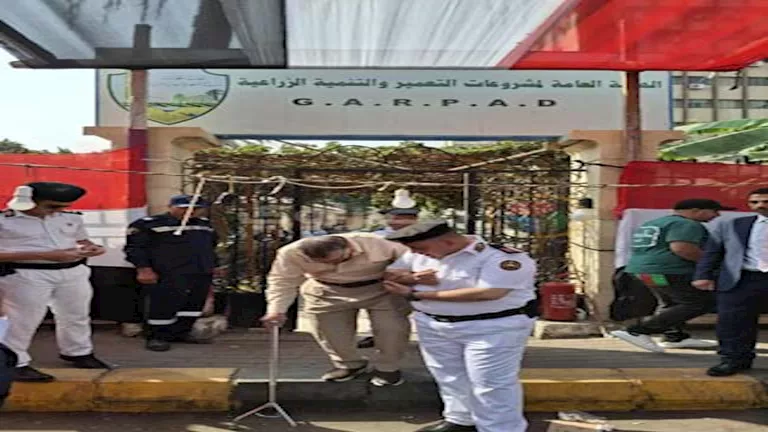 رجل شرطة يساعد مسنًا على الإدلاء بصوته في لجنة بالجيزة