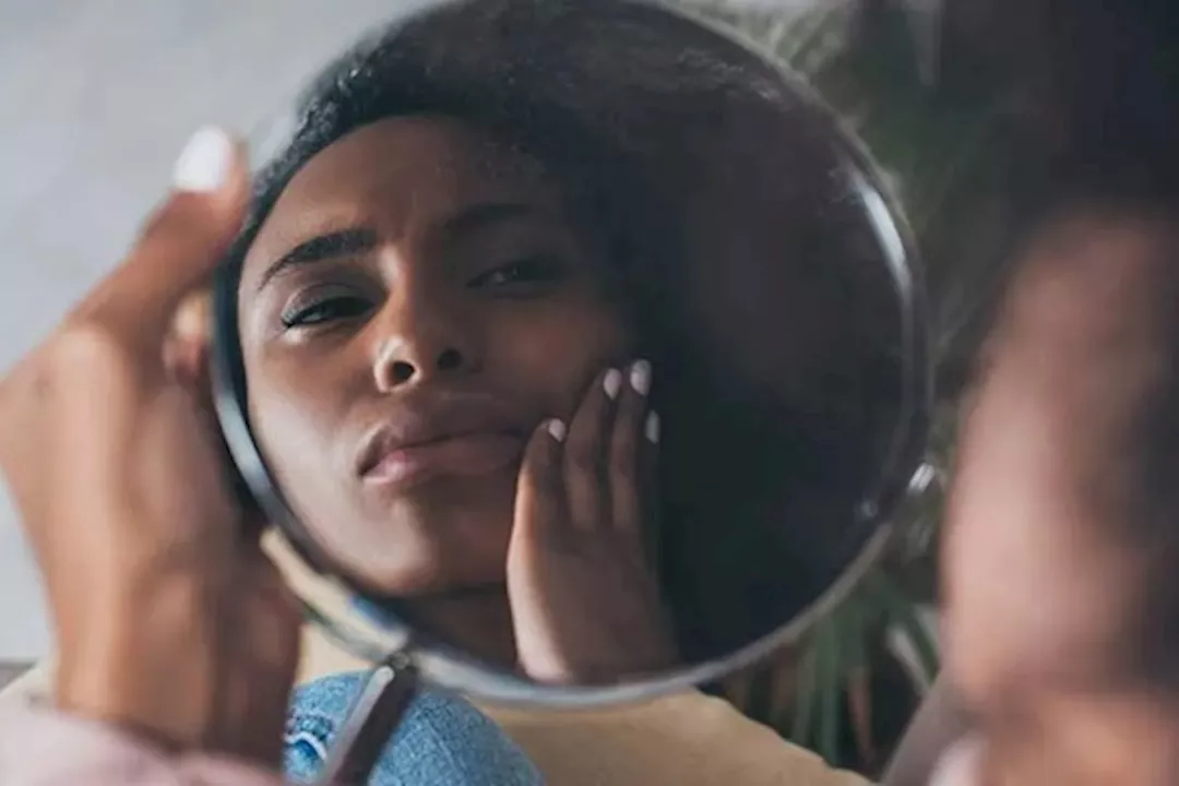 البحث عن أعراض الكلى على الوجه أمام المرآة