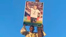 حبًا في اللاعب محمود صابر.. مواطن يتسلق عمود إنارة لرفع صورته بكفر الشيخ (صور)