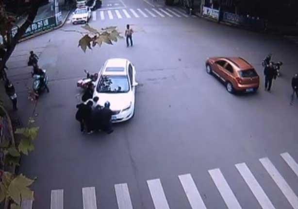 رفع سيارة سقطت على امرأة صينية 
