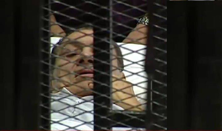 مبارك يدخل قفص الاتهام على سرير طبي ويلوح لأنصاره 