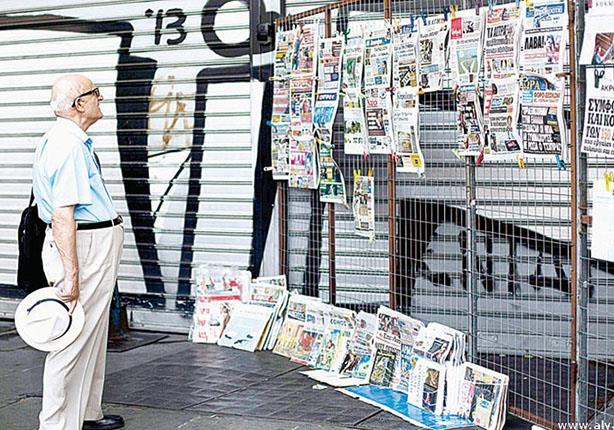 مواطن يوناني يتصفح المطبوعات اليومية