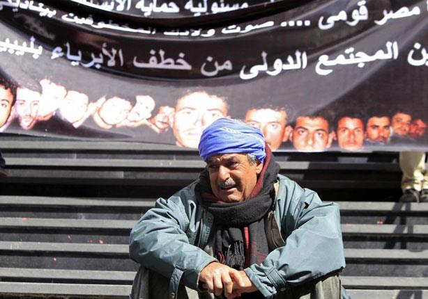 والد أحد المخطوفين أمام لافتة منددة بخطف المصريين 